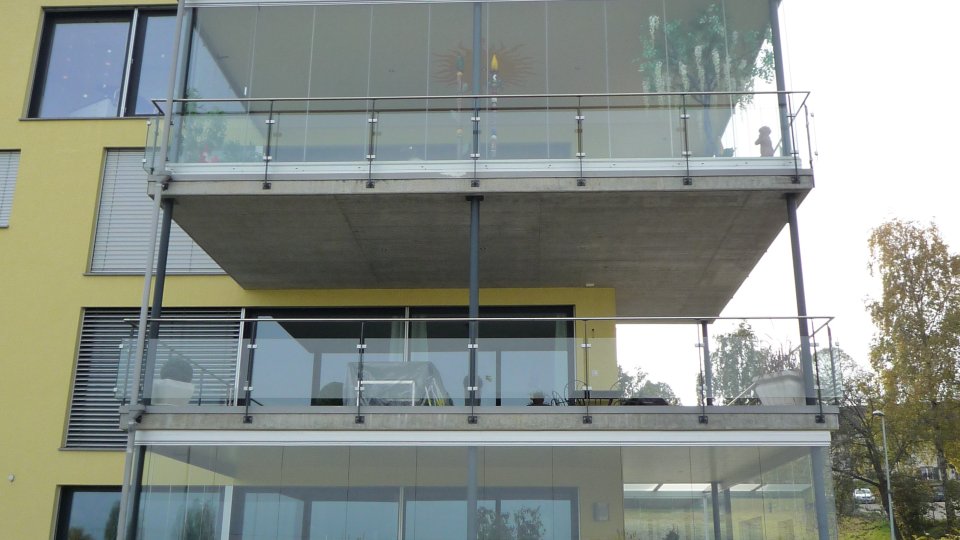 Torre di balconi su più piani con vetrata scorrevole-girevole COVER su una casa d’abitazione gialla