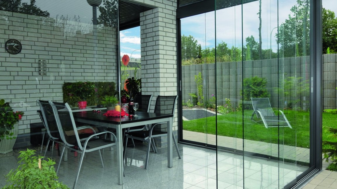 Coin repas lumineux avec toit en verre et vitrage coulissant SLIDER, table et vue sur le jardin