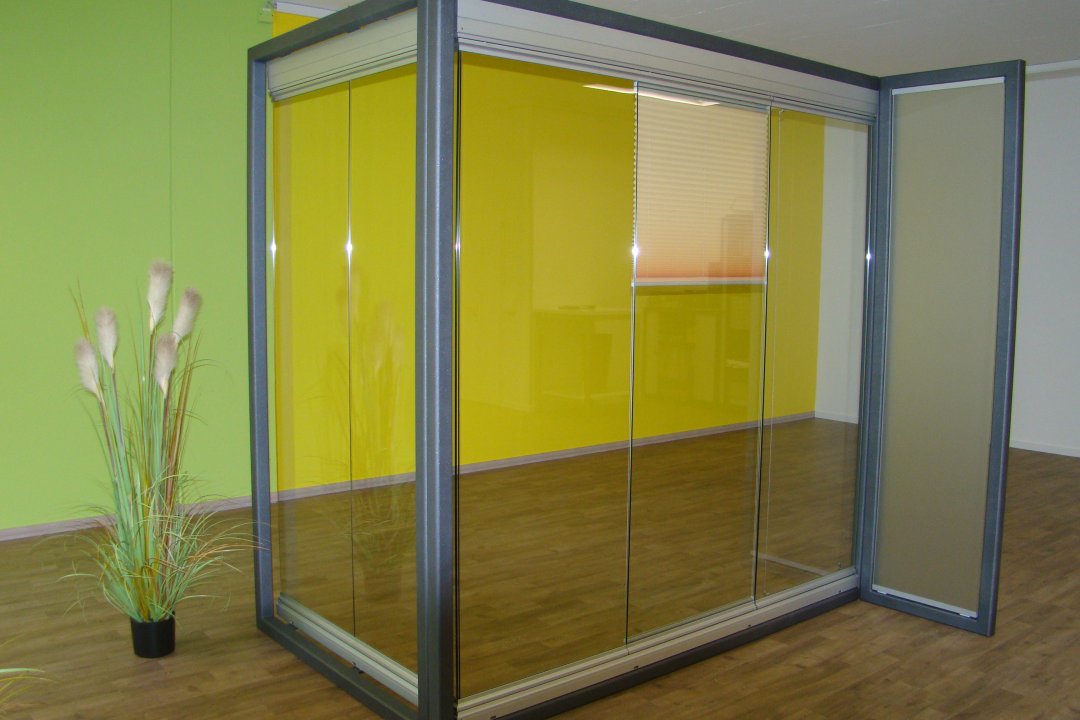 Modèle d’exposition d’un vitrage à profilés en aluminium gris, avec vantail ouvert et store plissé